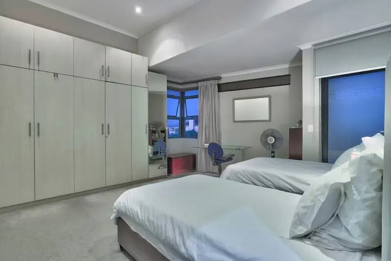 twin bed bedroom with built-in cupboards and desk to study